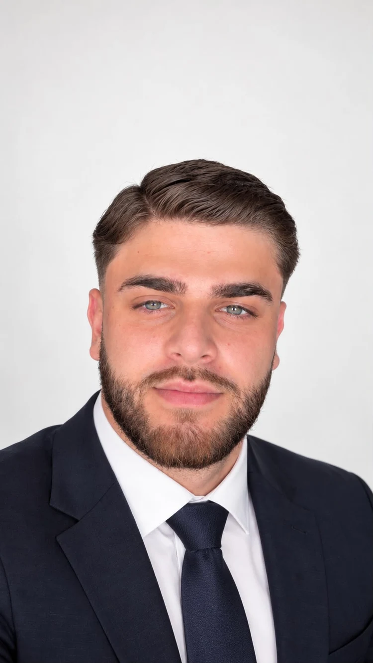 Dilan Shuker im dunklen Anzug mit Krawatte